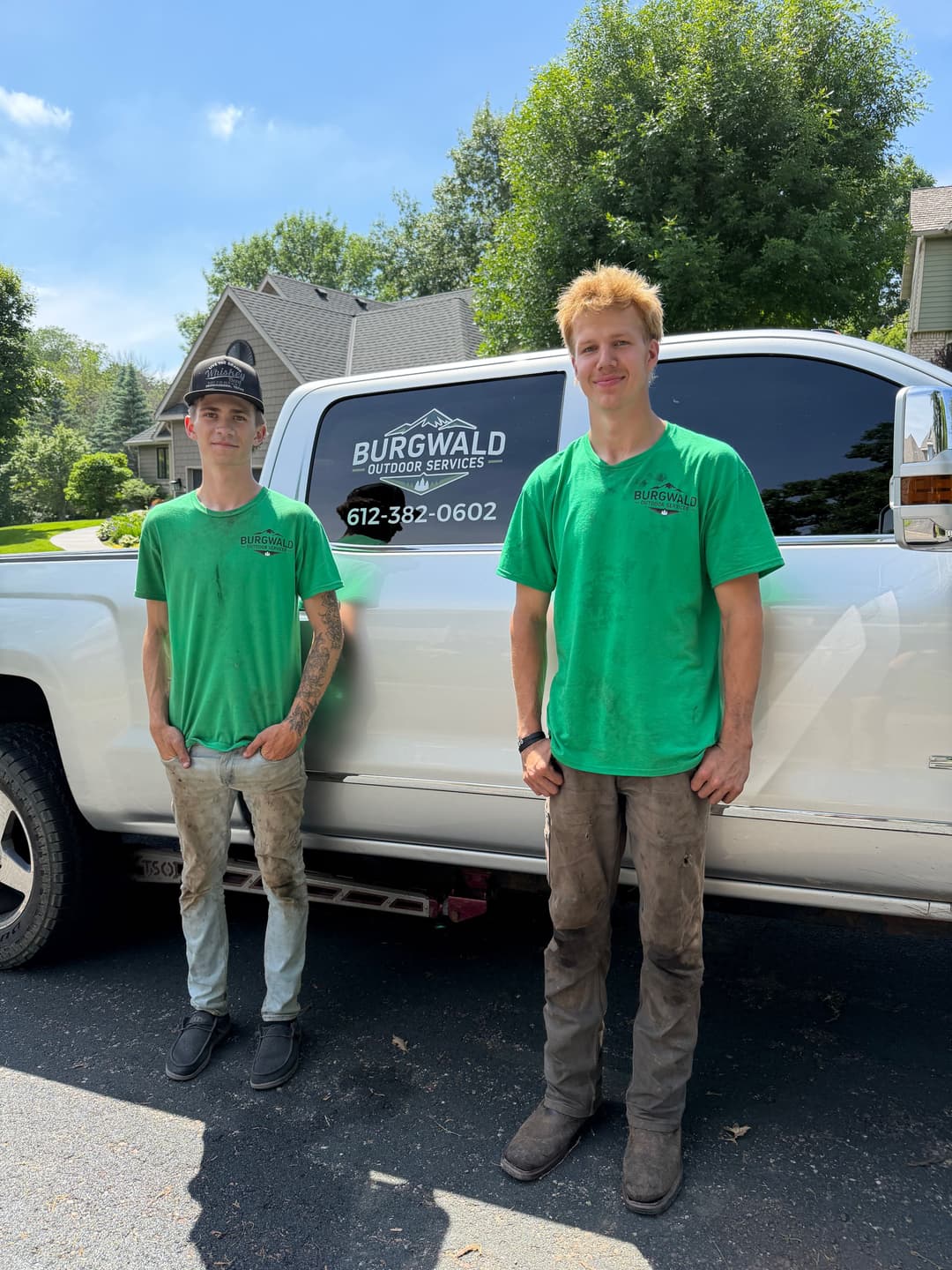 Burgwald Outdoor Services team members in green shirts beside their truck.